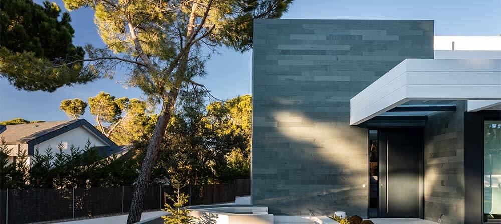 entrada de vivienda moderna con fachada de piedra natural en pizarra celeste