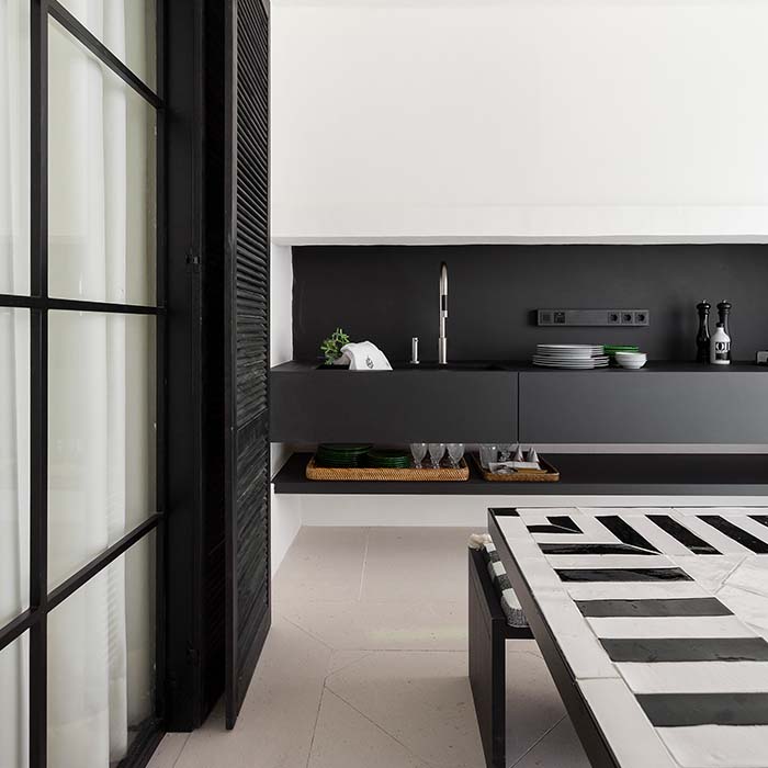 cocina blanca con muebles y encimera en negro