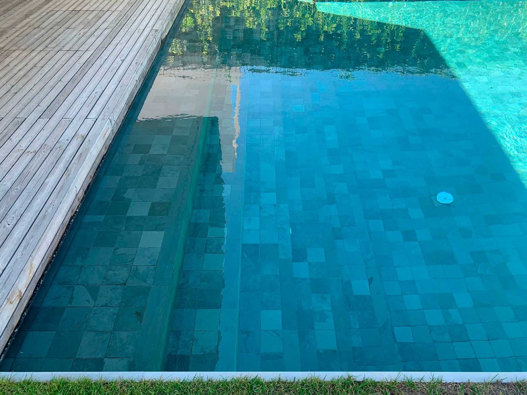vaso de piscina de color turquesa gracias a la instalación de mosaico de pizarra dentro de la piscina
